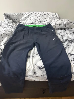 Svarta mjukisbyxor från BOSS - Snygga svarta mjukisbyxor från BOSS med elastisk midja och grön insida. Byxorna har en stilren design med logotypen BOSS tryckt på sidan, samt praktiska fickor. Perfekta för chill eller träning.