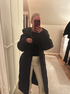 Svart pufferjacka med huva - Säljer en svart pufferjacka med stor huva och dragkedja framtill. Jackan har en oversized passform och är perfekt för kalla dagar. Den är tillverkad i syntetmaterial och har långa ärmar. Enkel och stilren design som funkar till många olika outfits. Skriv för fler bilder 💕