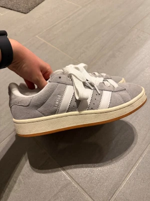 Adidas Campus 00s  - Säljer ett par Adidas Campus sneakers i grå mocka.  Sparsamt använda. Nypris kring 1500kr. 