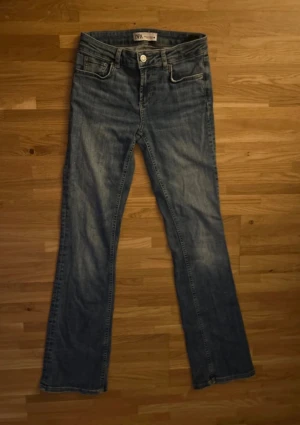 Blå bootcut jeans - Super snygga blåa, bootcut, low-midrise jeans från Zara. Midjemått: 32cm, innerbenslängd:76-77cm. 