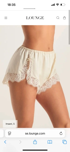 Krämfärgade spets-shorts från Lounge - Superfina krämfärgade shorts från Lounge med bred spetskant och mjuk, glansig yta. De har hög midja och elastisk resår, vilket gör dem både bekväma och snygga. Perfekta för chill hemma eller som en del av en söt pyjamas. Helt nya med prislapp kvar! 