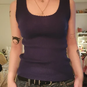 Mörkblå stickad linnetopp - Mörkblå stickad linnetopp med rundad halsringning och diskret virkad kant.