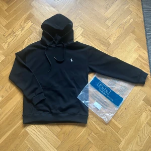 Svart hoodie från Polo Ralph Lauren - Grymt skick, inga skador, storlek L men sitter mer som M, påsen följer med i köpet!