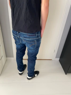 Dondup jeans George - Snygga blå jeans från dondup George i skinny fit-modell. Jeansen har klassisk femficksdesign, kontrastsömmar och en mörkblå tvätt med lätt slitning. Passformen är tight och materialet är mjukt jeans-tyg som sitter skönt hela dagen.