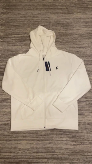 Vit Ralph lauren zip hoodie - Säljer en vit Ralph lauren zip hoodie i storlek S. Priset är inte fast men ni kan oxå köpa för paketpris om ni köper en till Ralph lauren tröja så kan vi gå ner i pris.😁