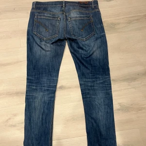 Dondup  - Säljer ett par klassiska dondup i blå tvätt med snygga slitningar. Jeansen har knappgylf, fem fickor och kontrastsömmar. Perfekt för dig som gillar tidlös stil och vill ha ett par jeans som funkar till allt. Finns 1 defekt se den på bild 3 men det syns inte när du har på dig dom 