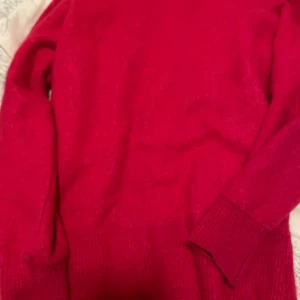 Rosa stickad tröja från Lira i alpaka blandning - Snygg rosa  stickad tröja från Lira med klassisk rund hals och långa ärmar. Perfekt för dig som gillar färgstarka plagg och vill ha något mjukt och bekvämt. Ribbstickade muddar vid ärmslut och nederkant ger en schysst passform. 