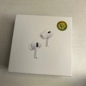 AirPods Pro 2 - Apple AirPods Pro i nyskick, komplett med förpackning, laddningsetui, kabel och extra öronproppar. Trådlösa hörlurar med aktiv brusreducering och transparensläge. Allt ser oanvänt ut och plastskydd sitter kvar. Perfekt för musik, samtal och träning. 1:1 replika