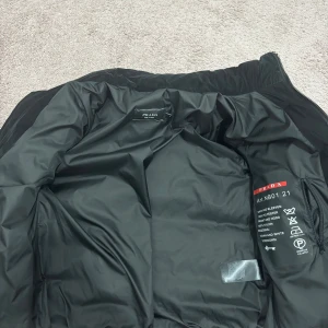 Svart jacka - Säljer en svart jacka med ribbade ärmar och quiltad front. Jackan har dragkedja framtill, två fickor med dragkedja och diskret. Materialmix av polyester, nylon och dun för en riktigt schysst look.