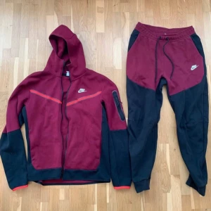 Nike vinröda och svarta mjukisbyxor M - Säljer ett par snygga mjukisbyxor från Nike i vinrött och svart. Byxorna har dragsko i midjan, muddar vid bensluten och klassisk Nike-logga på låret. Perfekta för chill eller träning, tillverkade i mjukt bomullsmaterial för maximal komfort.