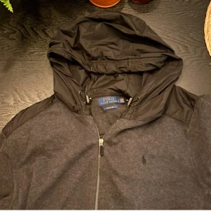  Polo Ralph Laurent cardigan  -  Säljer en svart/grå Polo Ralph Lauren cardigan som är sjuk snygg och skön. Står att det är L men passar M bättre.Det passar perfekt tills alla olika typer av kläder. Ny pris 1899 och mitt pris är 849 men kan såklart diskuteras!!!. Hör av er med bud och frågor.