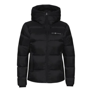 Svart dunjacka från Sail Racing S - Svart dunjacka från Sail Racing med huva och diskret logga på bröstet. Jackan har en puffig design, dragkedja framtill och två sidofickor. Perfekt för kalla dagar!                Ny pris 4 200kr