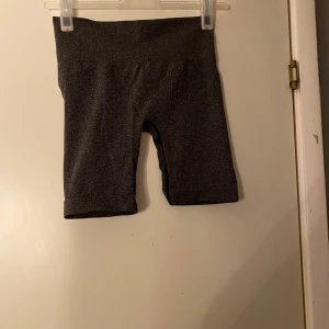 Mörkgrå seamless biker shorts - Säljer ett par mörkgrå seamless biker shorts med hög midja. De är stretchiga och sitter tight, perfekta för träning eller chill. Materialet är mjukt och andas, och shortsen har en clean look utan synliga sömmar framtill.