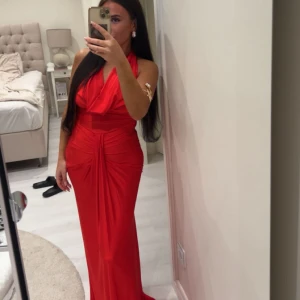 Röd långklänning med drapering - Använd endast ett par timmar, passar alla, materialet är i stretch. 