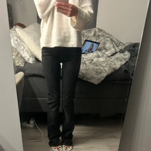 Svarta bootcut jeans - Säljer ett par svarta jeans med bootcut-modell. Jeansen har en klassisk femficksdesign och sitter tajt upptill med utsvängda ben nertill. Materialet är jeans och färgen är mörk svart, vilket gör dem enkla att matcha med olika outfits.