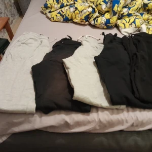 Fyra par mjukisbyxor i svart och grått - Fyra par mjukisbyxor i svart och ljusgrått med resår och snörning i midjan. Perfekta för chill dagar eller när du vill vara extra bekväm. Byxorna har en klassisk passform och är gjorda i mjukt material. Storlek S