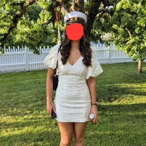 Vit kort studentklänning från Gina Tricot - Superfin vit kort studentklänning från Gina Tricot med puffiga ärmar och v-ringning. Klänningen har ett strukturerat tyg som ger en lyxig känsla. Jag hade den här på min student och var otroligt nöjd. Inga defekter och är bara använd på studentdagen