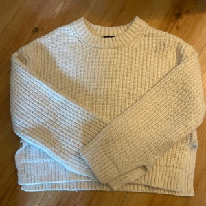  stickad tröja från Gina Tricot - Supermysig stickad tröja från Gina Tricot med breda ärmar och ribbade muddar. Har haft tröjan ett tag men har använt den få gånger, där med är tröjan i bra skick. Tröjan är vit/beige