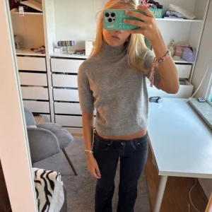 Grå croppad polotröja från Zara - Supermysig grå polotröja från Zara i croppad modell med ribbad hals och korta ärmar. Stickad i mjukt material som känns skönt mot huden. Endast använd en gång 