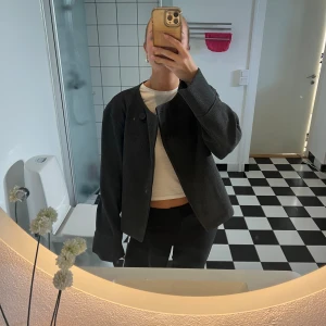 Grå kort kappa från Gina - Säljer denna supersnygga korta kappan från Gina Tricot. Kappan är aldrig använd då jag har en näst intill exakt likadan🙈🙈 Den är helt oanvänd med prislapp och extra knapp kvar🩷🙌🏻