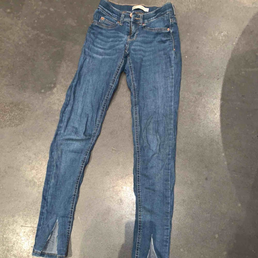 Ett par asnajs blåa jeans med slits nertill. Använd några gånger men i väldigt bra skick. Passar en xs/s. Köparen står för eventuell frakt. Jeans & Byxor.