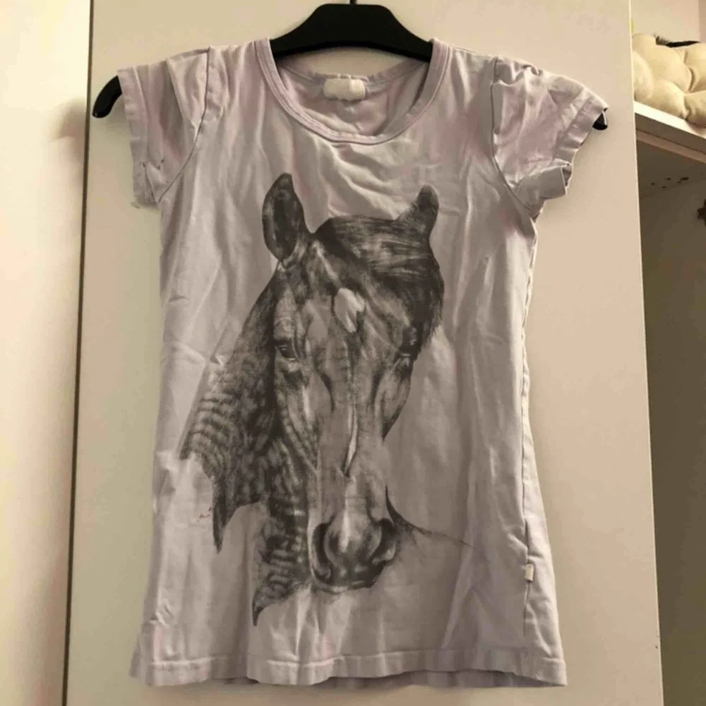 En fin häst T-shirt. Har blivit använd en del, det finns två små fläckar från målarfärg, den ena syns på sista bilden och den andra är på armhålan. . T-shirts.