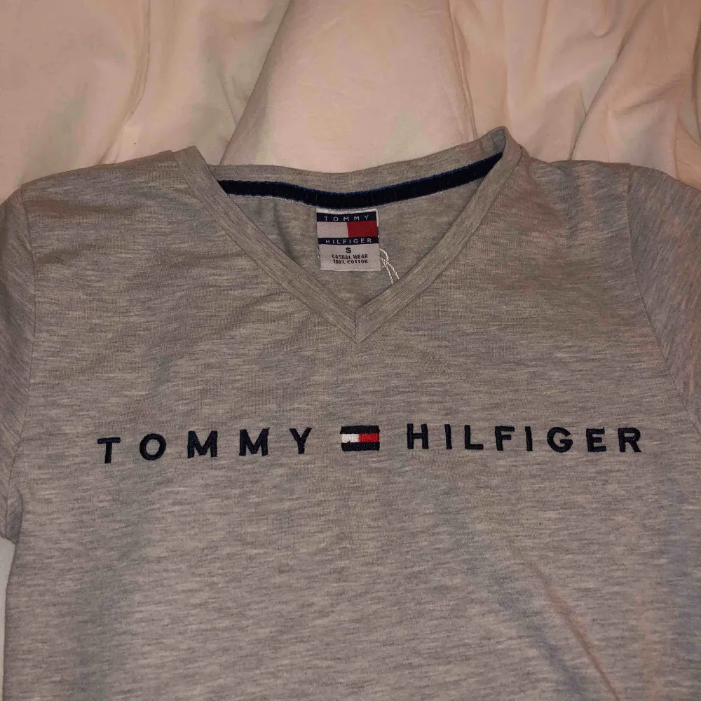 Tommy Hilfiger - grå, v-neck, det står S på tröjan men passar även XS. T-shirts.