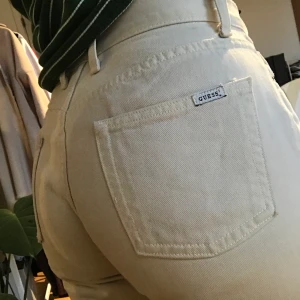 Guess jeans i en naturligt/beige färg  - Säljer ett par vintage jeans från guess som jag köpt från second hand för ett par månader sedan. En liten detalj är förstörd där man sätter i bältet men det är enkelt att sy igen den! Kan skicka bild på dm vart jag menar. Storlek 27 och ser väldigt vintage och ej slitet ut. 