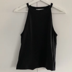 Svart linne  - Svart linne med en liten öppning i ryggen. Två slitsar, en på vardera sida. Ganska hög i halsen