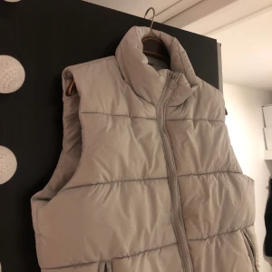 Grå dunväst S - Fett fin grå dunväst. Perfekt skick. Som ny. Storlek S men lite oversized. Frakt tillkommer. Budgivning om många vill köpa. BARA SERIÖSA KÖPARE.  Bud just nu: 720kr