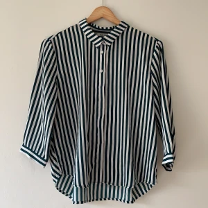 Grönvit randig skjorta  - Grönvit randig skjorta. Använd någongång alltså helt i nyskick. Mycket fin från monkie. Omlåt detalj på ryggen 