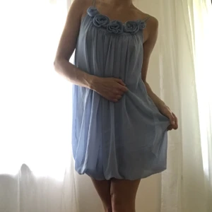  - Drömblå klänning med rosor. Frakt 35 kr