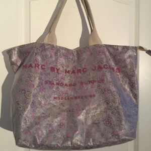  - Säljer min superfina väska från Marc Jacobs! Jättefin till sommaren som tex strandväska. Jättefint skick förutom att innertyget gått upp på en sida inne i väskan men som lätt går att sys ihop och som inte syns utanpå. Därav det billiga priset. Inköpspris låg på över 1000kr