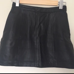  - Storlek 38, men passar snarare en 34. Kort kjol i äkta läder. Blir bara snyggare med åren!  Kan mötas upp i centrala Uppsala. Vid försändelse tillkommer frakt. Varan ligger ute på andra sidor/appar också.