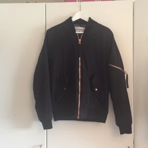  - Bombarjacka med bronsfärgade dragkedjor. Lite nopprig på insida. Köparen står för frakt. 