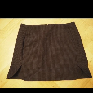  - kjol med små slitsar på sidorna samt fickor och dragkedja bak