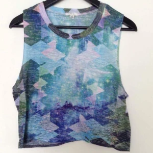  - Crop top med space mönster i tunt material med ficka på bröstet.