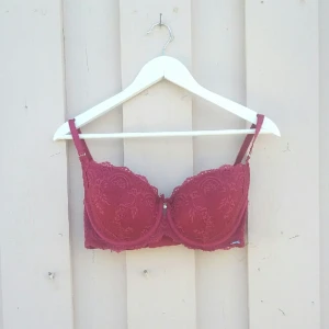  - Vinröd behå med vadderad kupa och spetsutsmyckning. Knappt använd pga föredrar ovadderat. 85% polyamid, 15% elastan.