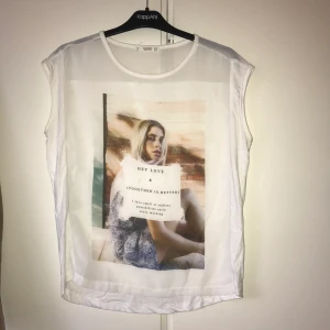 Topp med tryck - Superfin topp från mango med bildtryck på framsidan. Plagget är lite genomskinligt på framsidan som ni kan se på tredje bilden. Aldeig använd och som ny! 