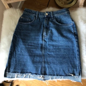 Jeanskjol - Högmidjad Jeanskjol med slit storlek 34. Då jag är mitt i en flytt har jag ej möjlighet att skicka fler bilder, vänligen respektera. 😊