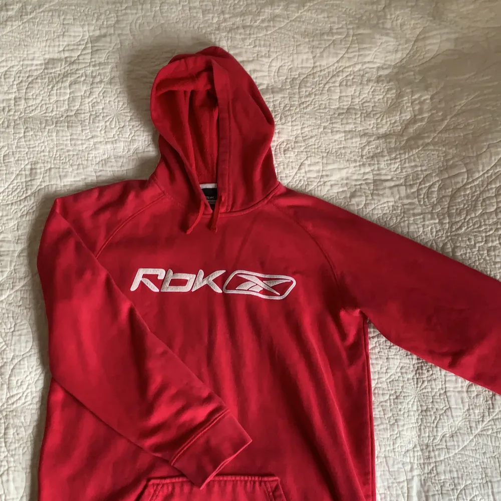 En röd lite urtvättad (på ett bra sätt) hoodie från Reebok. Jag har storlek xs och vill säga att den sitter prefekt på mig! . Tröjor & Koftor.