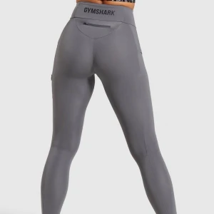 Gymshark non-stop leggings  - Gråa oanvända tights från gymshark, med en text bak och ficka på sidan. Liten i storleken, mer en XS.  Säljer eller om någon kan byta mot likadana i storlek M. Frakt 44 kr. Originalpris: 600 kr