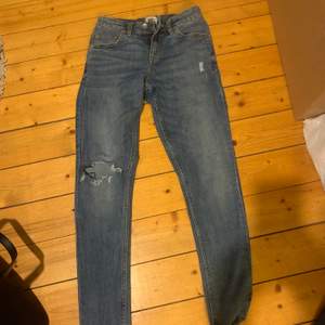 blåa jeans ifrån lager 157 med hål på ena knät. strl xs men skulle även passa s