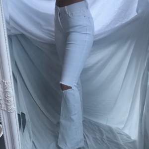 Vita jeans i bootcutmodell, med hål på ena knät. Passar XS-S, hyffsat stretchiga, bra skick