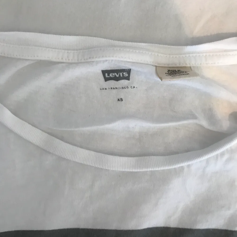 En vit t-shirt ifrån Levi’s med ett silvrigt/grått print, använt några gånger men utöver det är tröjan i gått skick! Nypris 299kr, du står för frakten🥰. T-shirts.