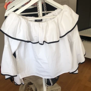 Vit blus med svarta detaljer i xs - Plagget är en vit blus med svarta detaljer i storleken xs. Blusen är från zara. Plagget är i bra skick och den är använd 1 gång. Jätte fin blus men tycvär lite för stor för mig. Jag köpte den för 400 kr för 2 år sen.