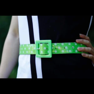 Prickigt limegrönt lackskärp - Limegrönt lackskärp med vita prickar & kantigt plastspänne. Gott skick (använt 1 gång).  Finns för avhämtning i Malmö, alt kan skickas (mot att köparen betalar frakten). Be