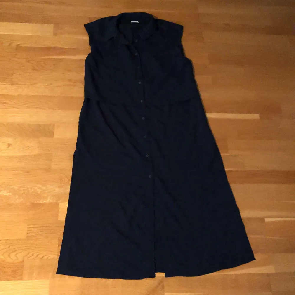 Mörkblå lång skjortklänning utan ärmar från Vero Moda storlek S. Luftig passform, dubbeltyg på toppdel.. Klänningar.