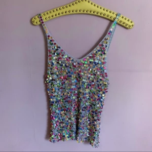 Vintage virkat linne m paljetter - Vintage linne. Stl: XS-M, beroende på fit. Elastiskt, har därför angett två mått! Mått: byst/armhåla-till-armhåla 31cm (stretchar upp till 45cm), vidd nertill 33cm (stretchar upp till 48cm), längd fr axel 62cm.