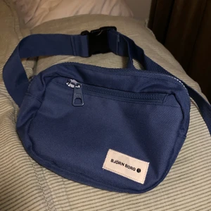 Väska från Björn Borg - Cross-body/midjeväska från Björn Borg som knappt är använd och i fint skick. Väldigt rymlig och med 2 fack, köptes för 250kr. Köparen står för frakt men annars kan jag mötas upp i Stockholm:)